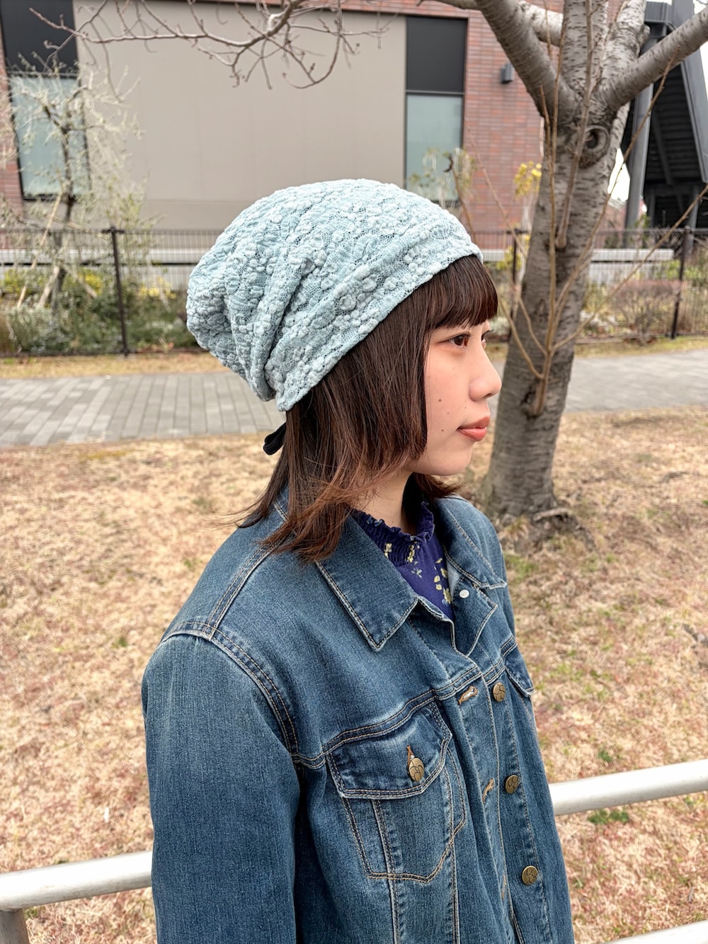 ブルー系のデニムジャケット、ブルー系のデニムパンツ、ホワイト系のスニーカーを着用したレディースの冬コーディネートの3枚目の写真