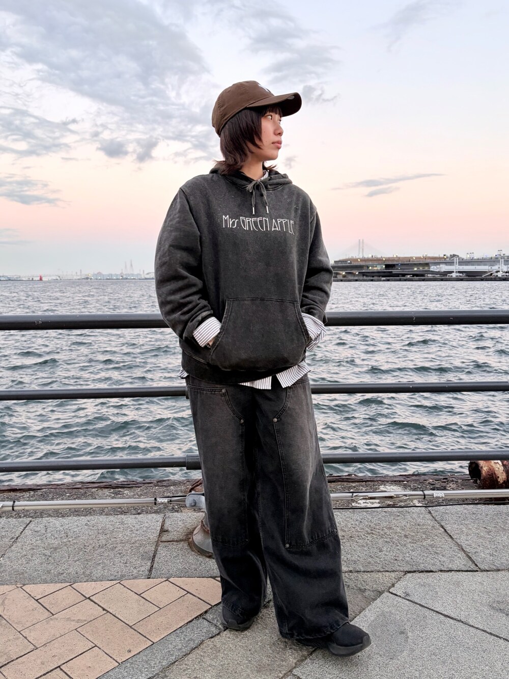 ブラック系のデニムパンツ、ブラウン系のキャップを着用したレディースの冬コーディネートの2枚目の写真