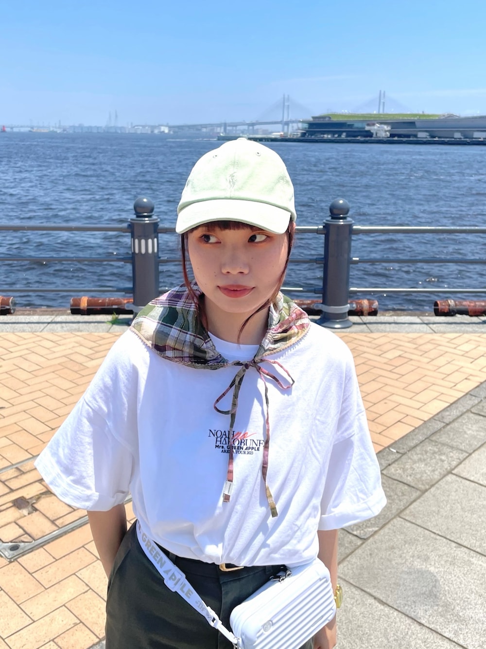 グリーン系のチノパンツ、ホワイト系のサンダル、グリーン系のキャップを着用したレディースの夏コーディネートの4枚目の写真