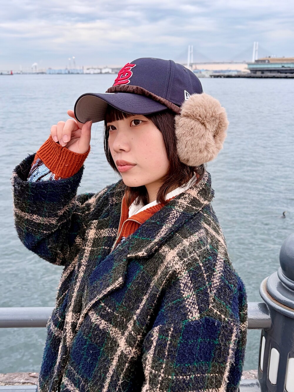 グリーン系のジャケット/アウター、オレンジ系のカーディガン/ボレロ、ブルー系のデニムパンツを着用したレディースの冬コーディネートの4枚目の写真