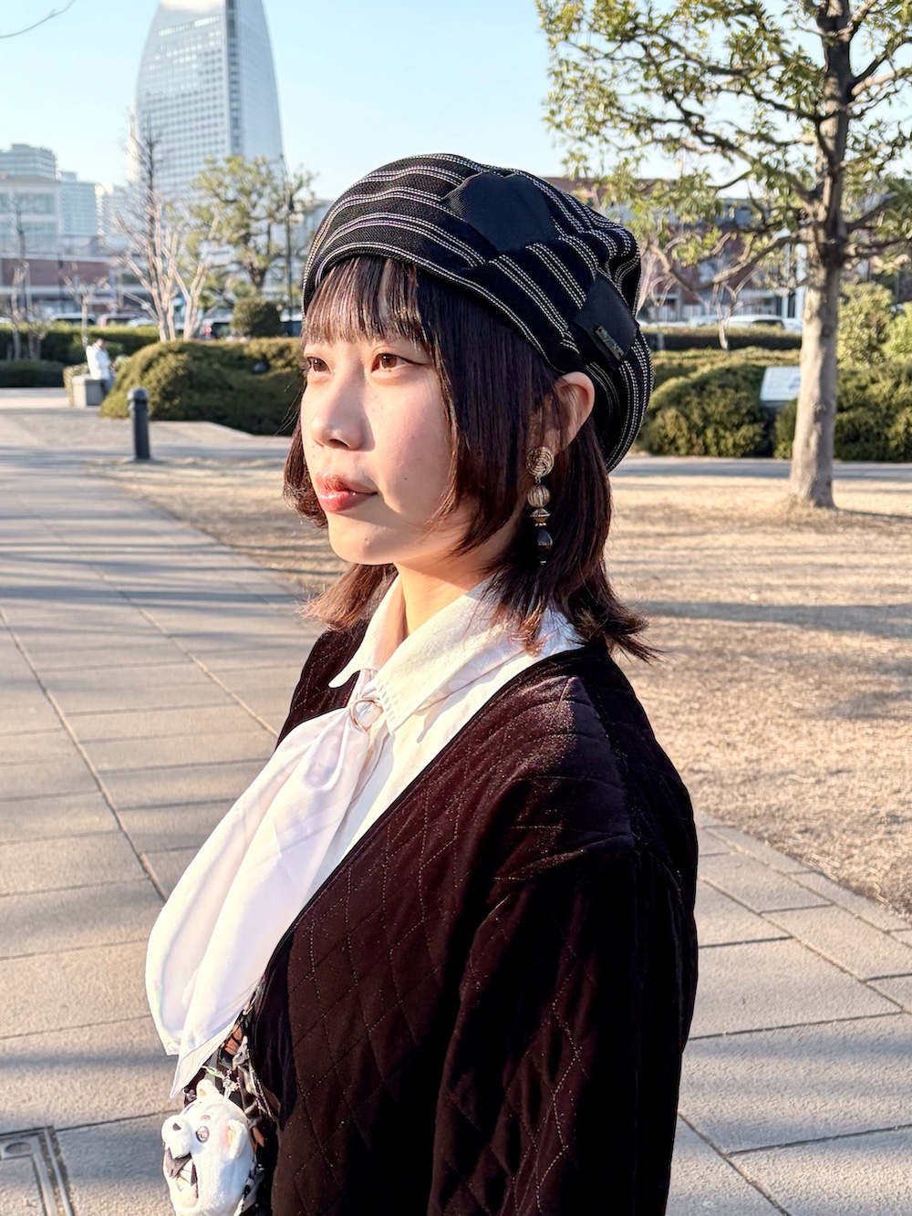 ブラック系のジャケット/アウター、ブラック系のスカート、ブラック系のスニーカーを着用したレディースの冬コーディネートの6枚目の写真