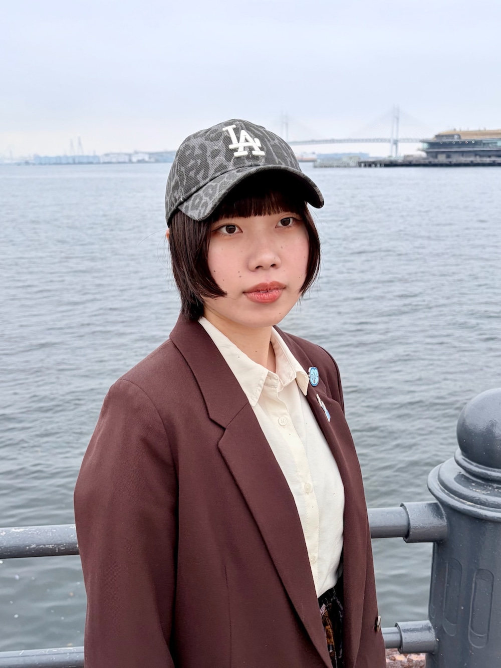 ブラウン系のテーラードジャケット、パープル系のパンツ、ブラック系のスニーカーを着用したレディースの春コーディネートの5枚目の写真