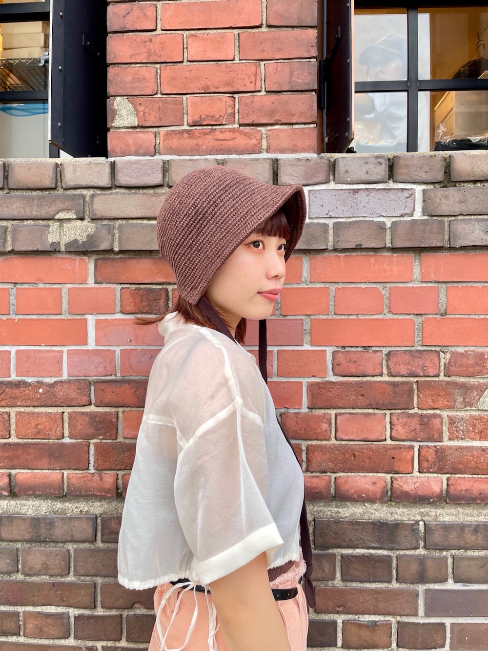 ホワイト系のシャツ/ブラウス、オレンジ系のデニムパンツ、ホワイト系のスニーカーを着用したレディースの夏コーディネートの3枚目の写真