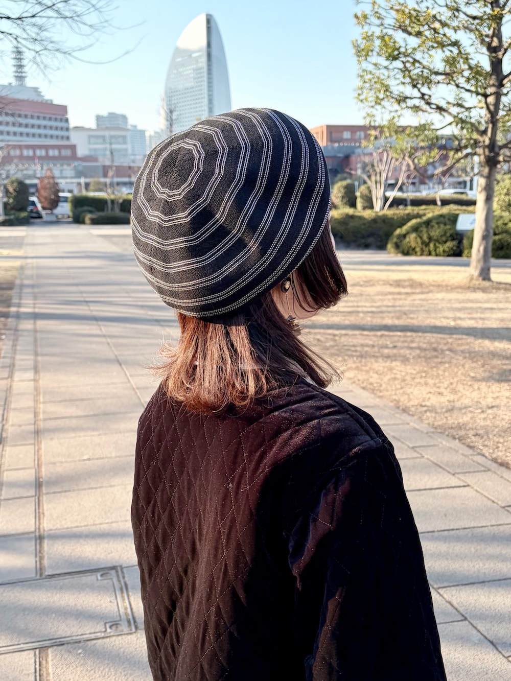 ブラック系のジャケット/アウター、ブラック系のスカート、ブラック系のスニーカーを着用したレディースの冬コーディネートの7枚目の写真