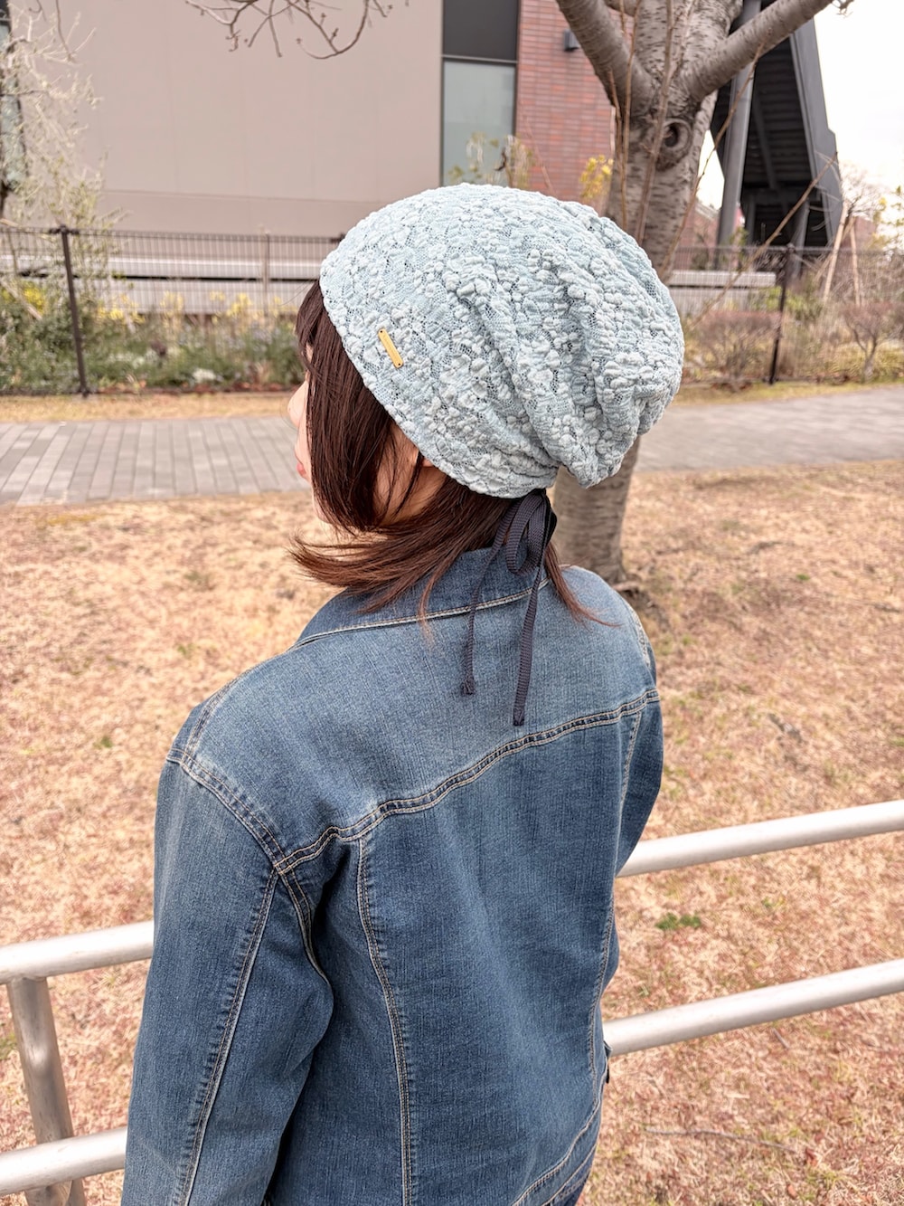 ブルー系のデニムジャケット、ブルー系のデニムパンツ、ホワイト系のスニーカーを着用したレディースの冬コーディネートの6枚目の写真