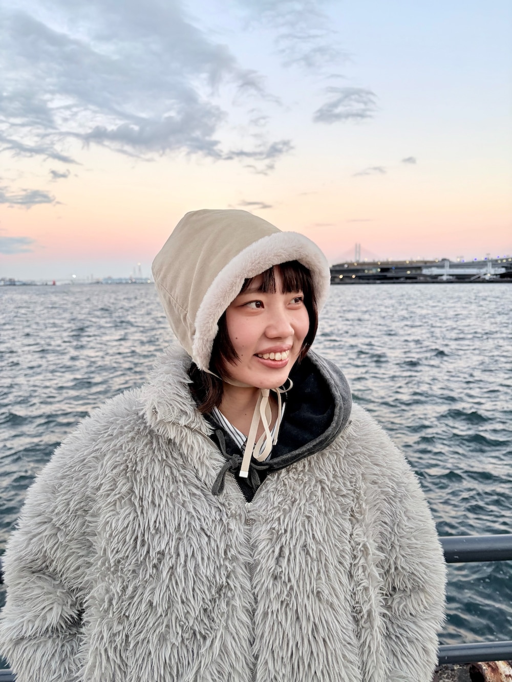 ブラック系のデニムパンツ、ブラック系のスニーカー、ホワイト系のハットを着用したレディースの冬コーディネートの4枚目の写真