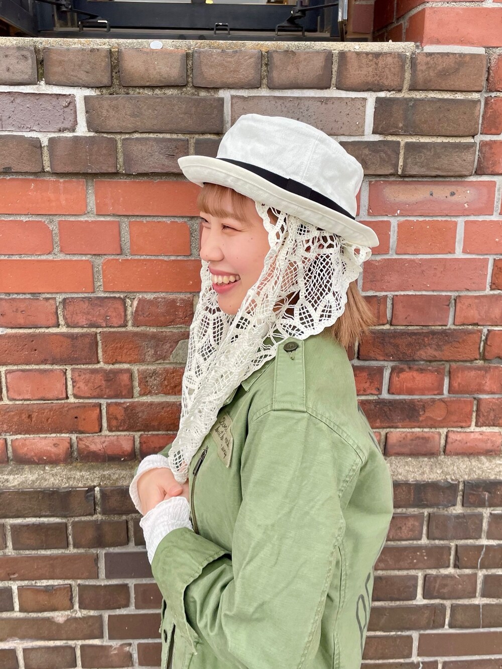 グリーン系のジャケット/アウター、ホワイト系のスカート、ホワイト系のスニーカーを着用したレディースの春コーディネートの6枚目の写真