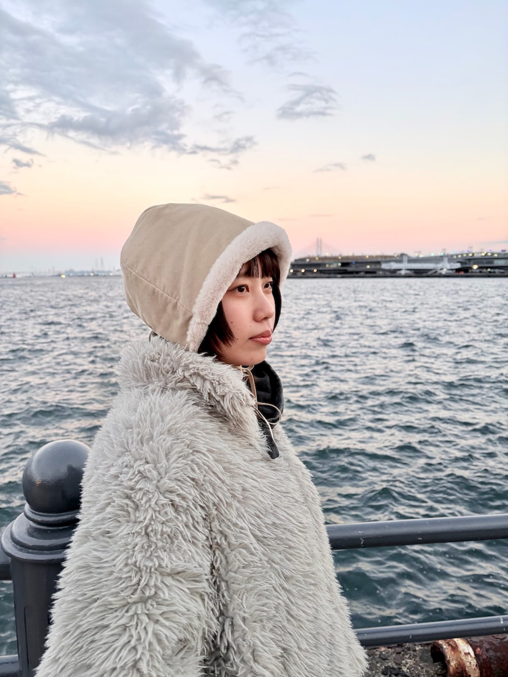 ブラック系のデニムパンツ、ブラック系のスニーカー、ホワイト系のハットを着用したレディースの冬コーディネートの3枚目の写真