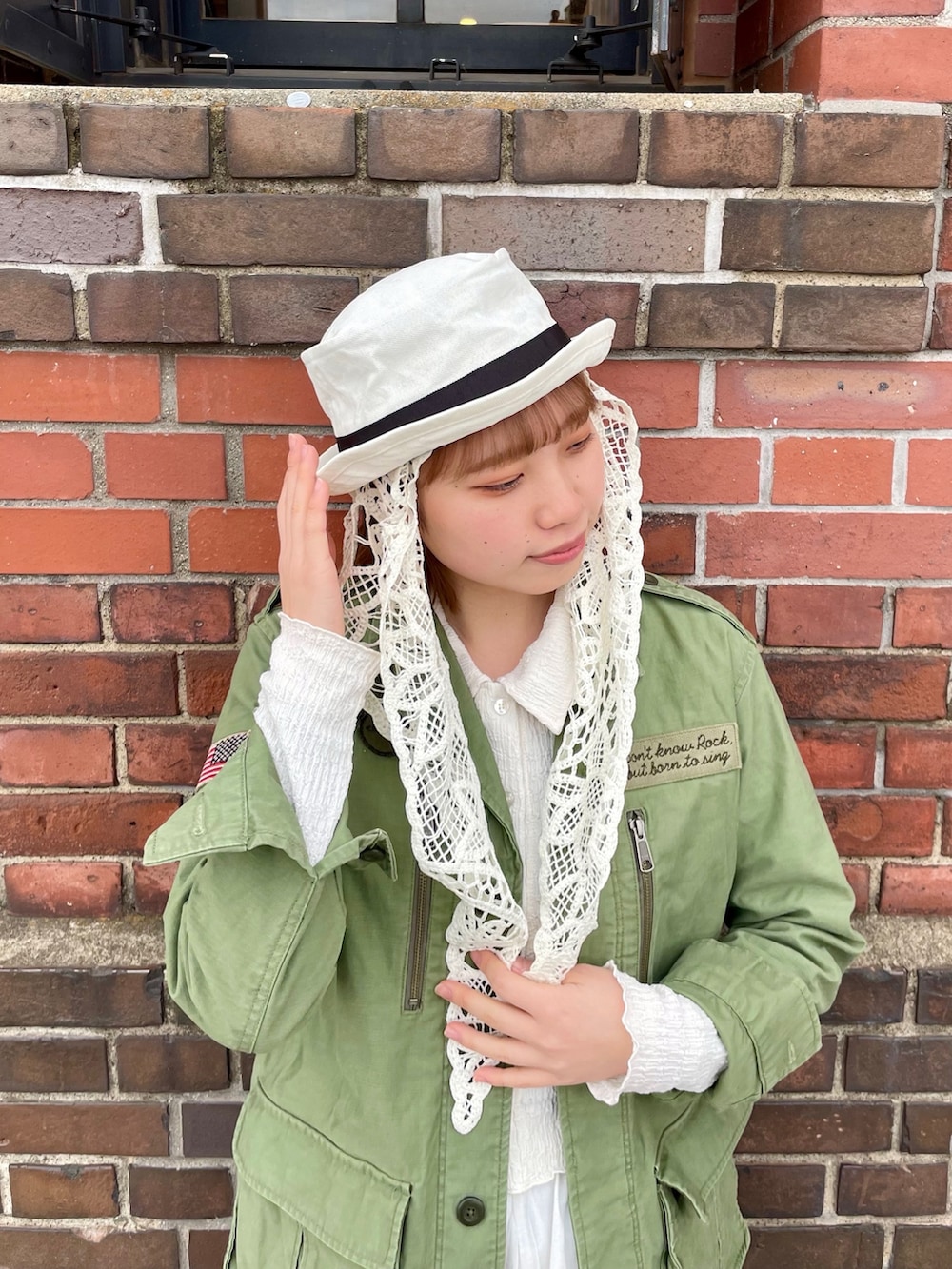 グリーン系のジャケット/アウター、ホワイト系のスカート、ホワイト系のスニーカーを着用したレディースの春コーディネートの4枚目の写真