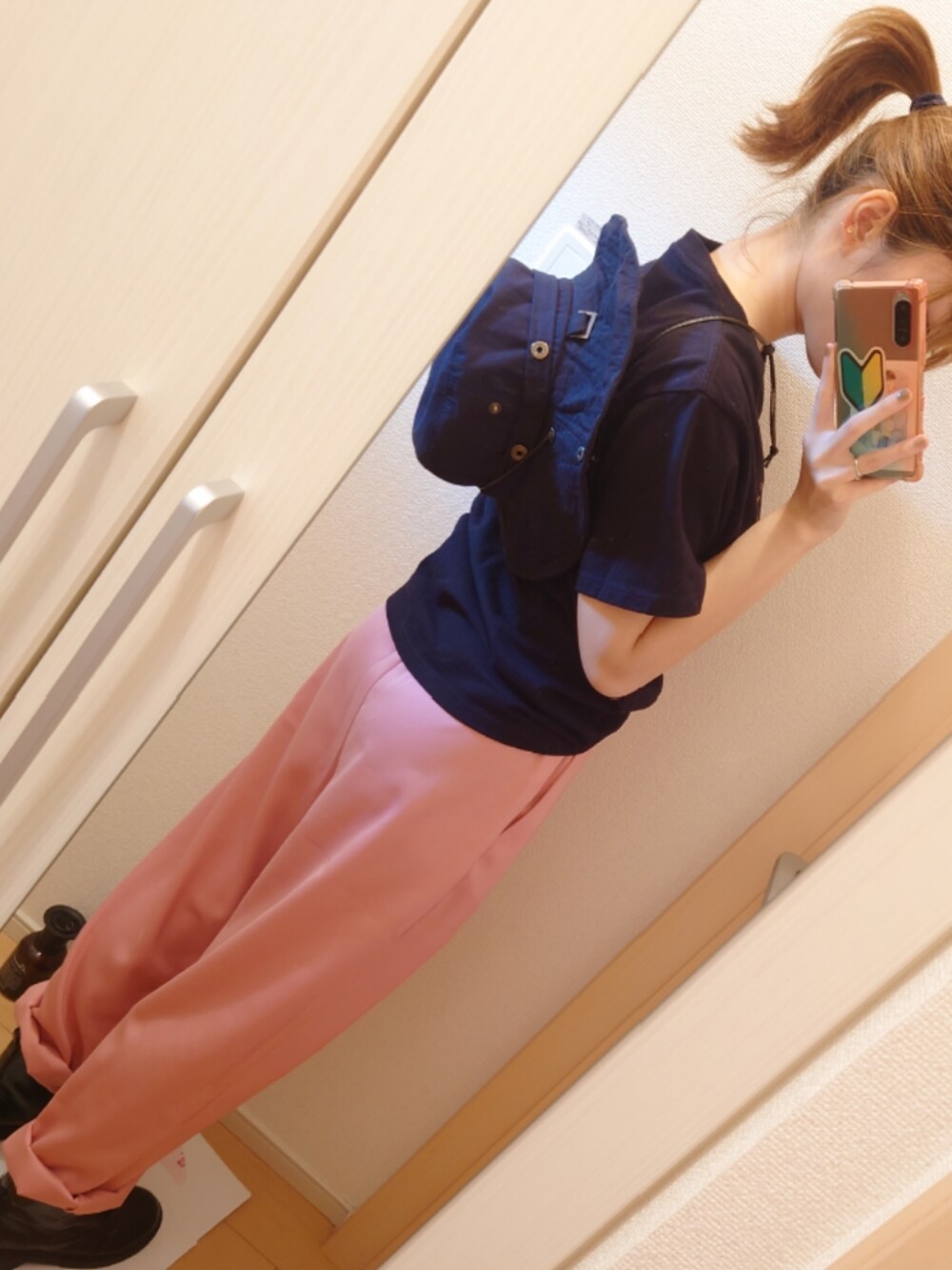 ピンク系のスラックス、ブラック系のTシャツ/カットソー、ブラック系のブーツを着用したレディースの秋コーディネートの4枚目の写真