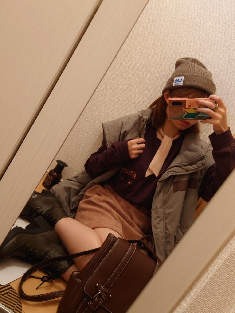 グリーン系のモッズコート、ブラウン系のTシャツ/カットソー、グリーン系のブーツを着用したレディースの秋コーディネートの3枚目の写真