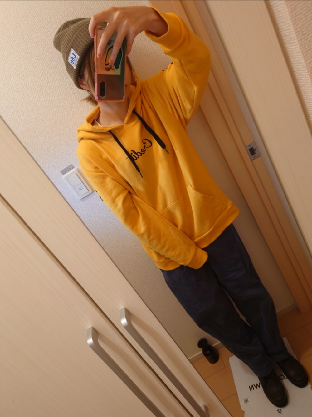 イエロー系のパーカー、ブルー系のパンツ、グリーン系のブーツを着用したレディースの秋コーディネートの2枚目の写真