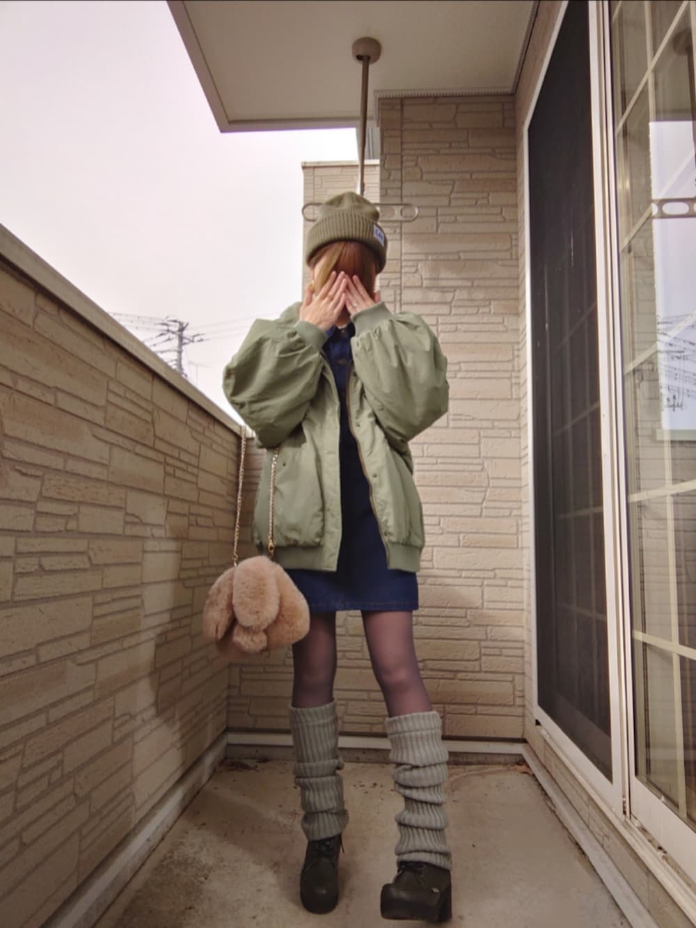 ブルー系のワンピース、ベージュ系のシャツ/ブラウス、グリーン系のモッズコートを着用したレディースの冬コーディネートの2枚目の写真