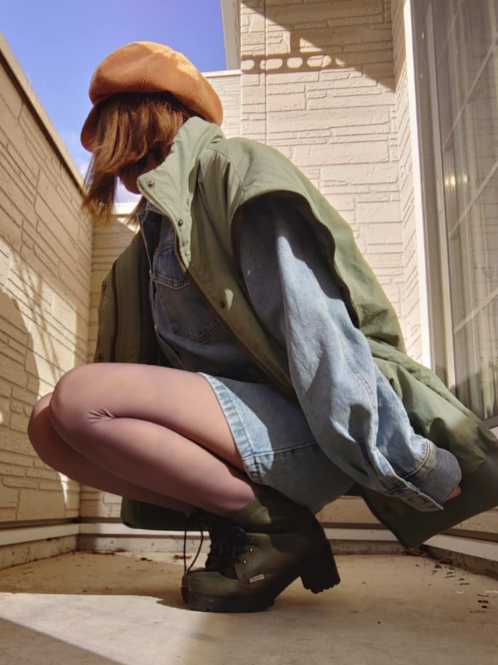 ブルー系のワンピース、グリーン系のモッズコート、グリーン系のブーツを着用したレディースの冬コーディネートの3枚目の写真