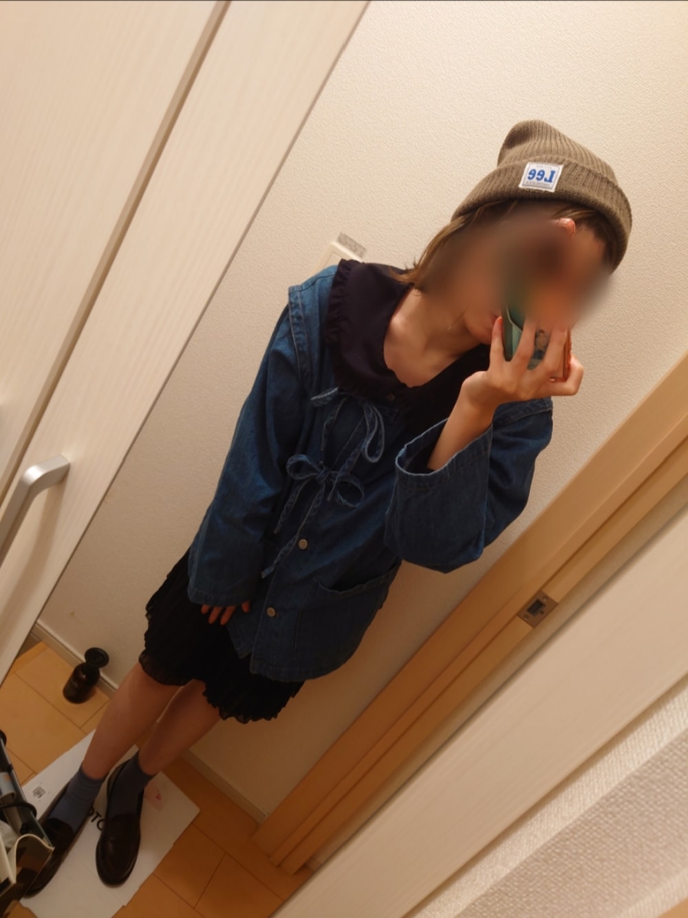 ブルー系のデニムジャケット、ブラウン系のローファー、ブラック系のシャツ/ブラウスを着用したレディースの秋コーディネートの2枚目の写真