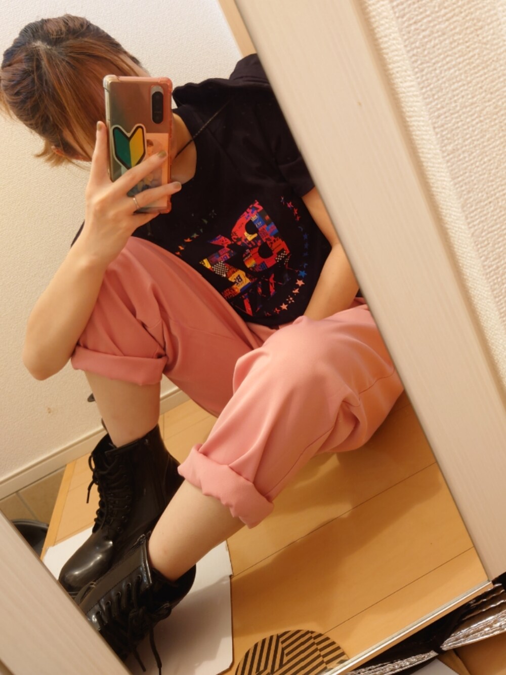 ピンク系のスラックス、ブラック系のTシャツ/カットソー、ブラック系のブーツを着用したレディースの秋コーディネートの2枚目の写真