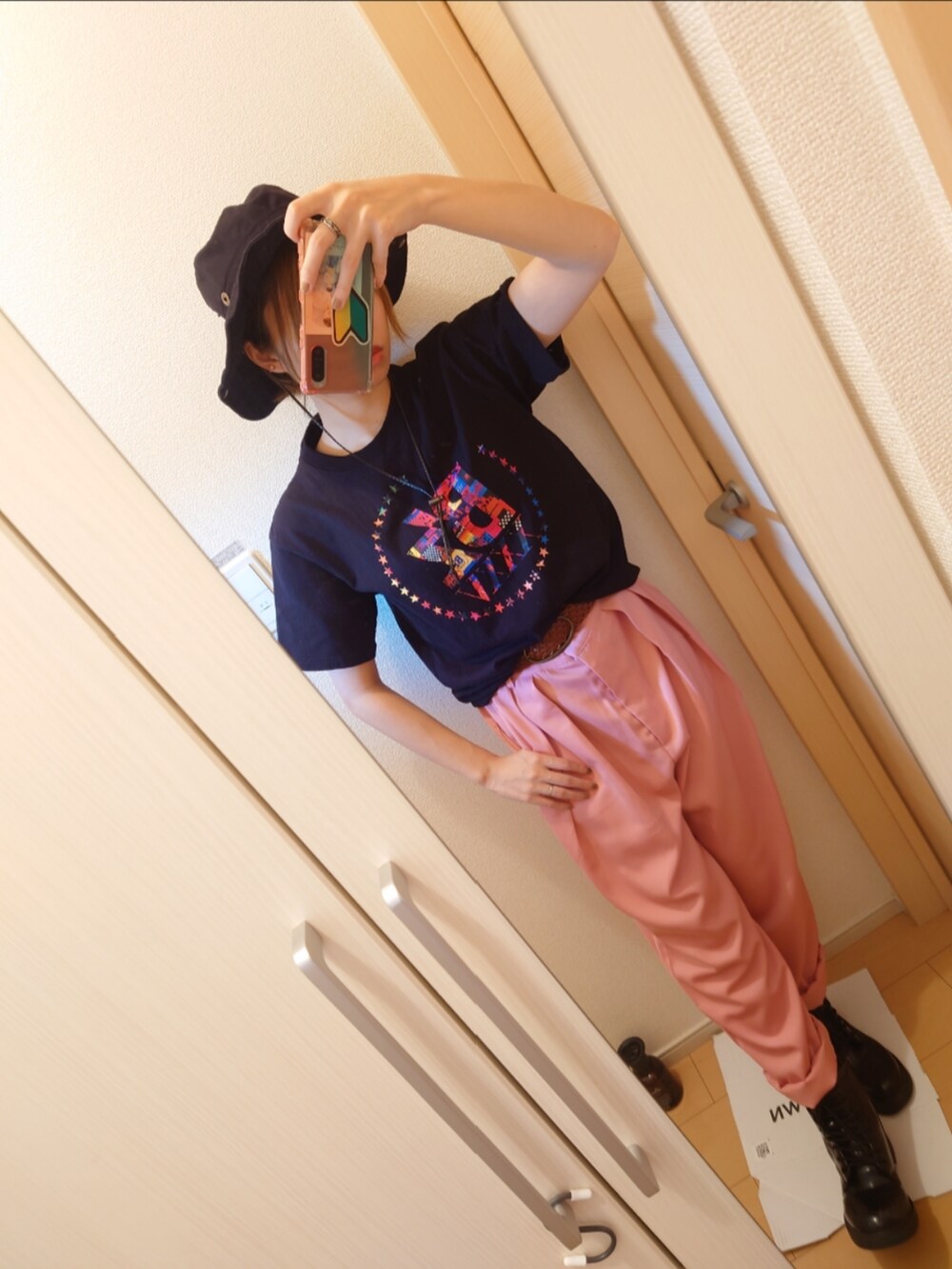 ピンク系のスラックス、ブラック系のTシャツ/カットソー、ブラック系のブーツを着用したレディースの秋コーディネートの3枚目の写真