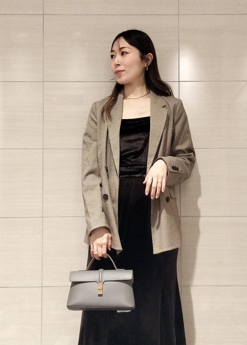 グレー系のショルダーバッグ、ベージュ系のテーラードジャケット、ブラック系のブーツを着用したレディースの秋コーディネートの2枚目の写真