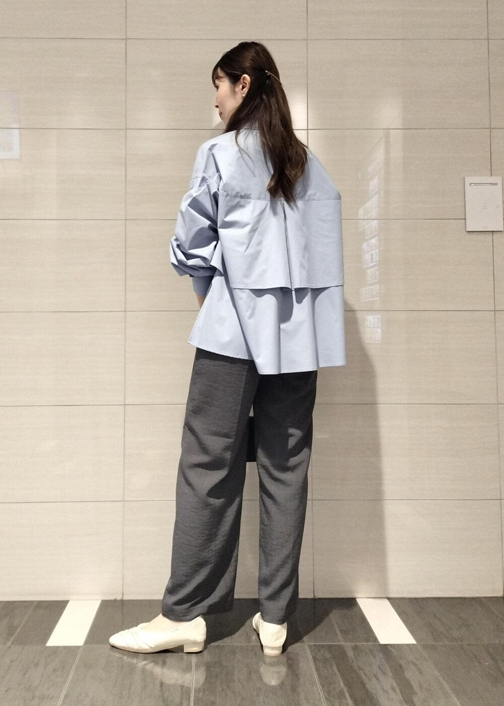 ブラック系のハンドバッグ、ホワイト系のキャミソール、グレー系のスラックスを着用したレディースの秋コーディネートの6枚目の写真