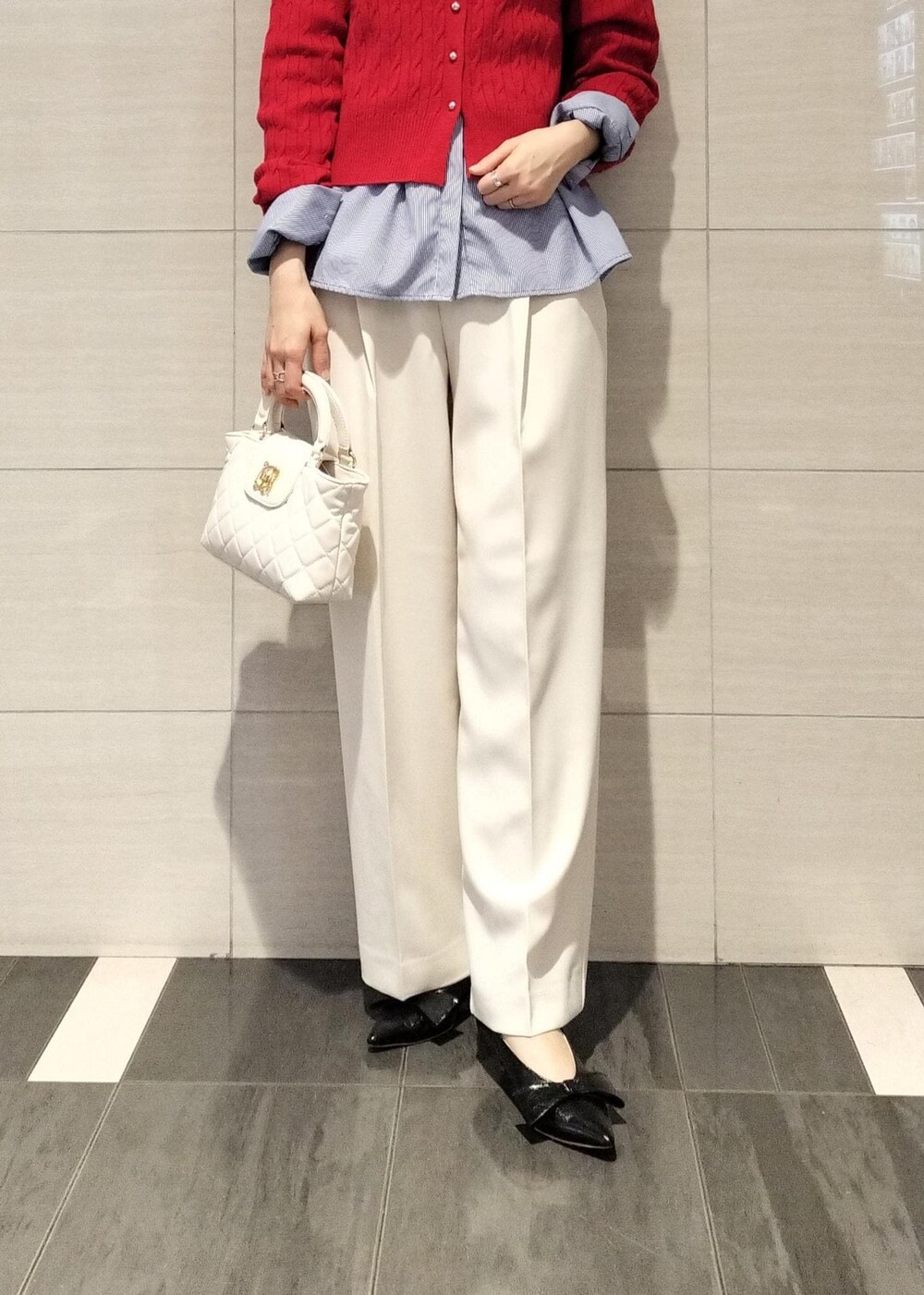 ブラック系のパンプス、ブルー系のシャツ/ブラウス、レッド系のカーディガン/ボレロを着用したレディースの冬コーディネートの5枚目の写真