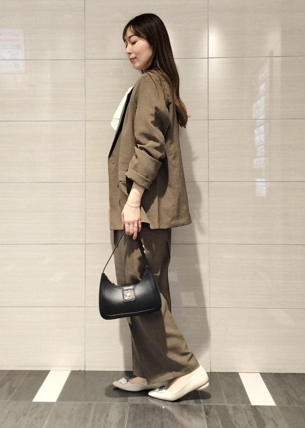 ブラック系のハンドバッグ、ホワイト系のシャツ/ブラウス、ホワイト系のバレエシューズを着用したレディースの春コーディネートの2枚目の写真