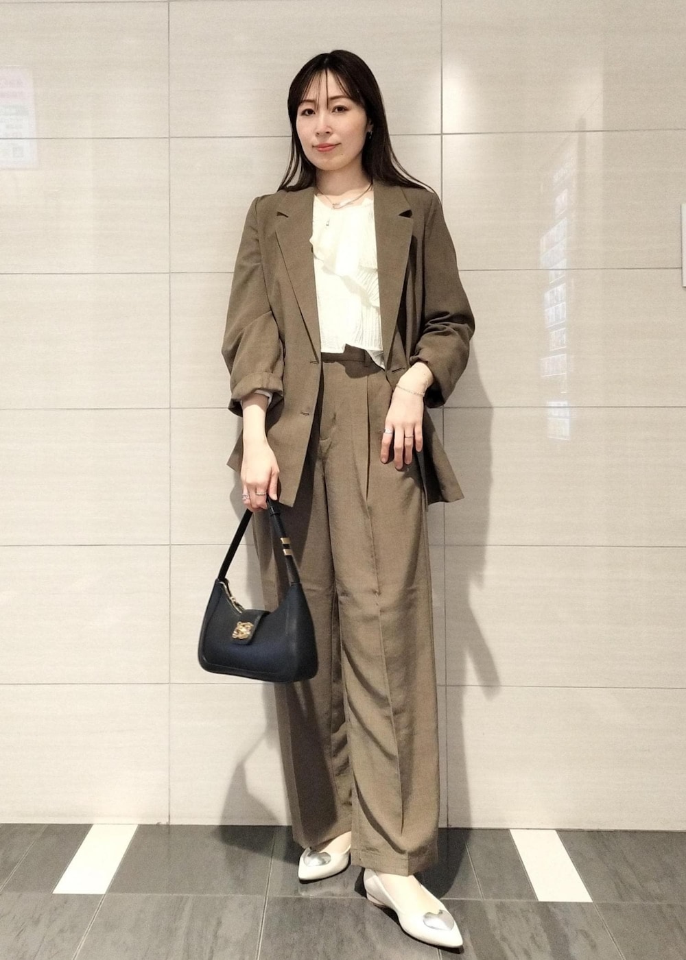 ブラック系のハンドバッグ、ホワイト系のシャツ/ブラウス、ホワイト系のバレエシューズを着用したレディースの春コーディネートの6枚目の写真