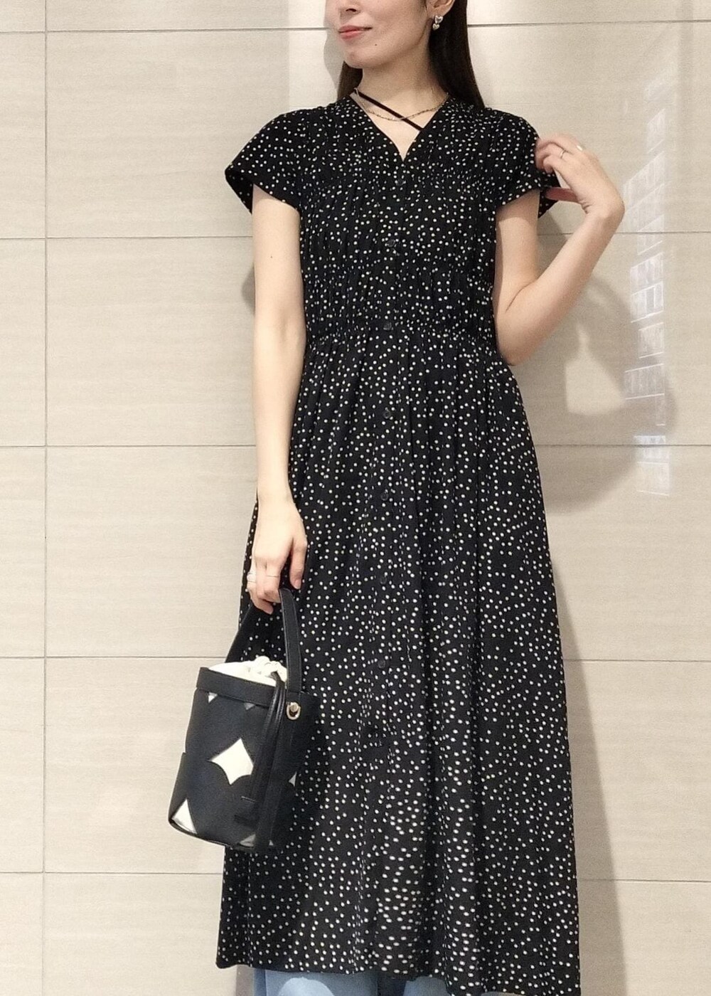 ブラック系のキャミソール、ブルー系のデニムパンツ、ブラック系のサンダルを着用したレディースの夏コーディネートの3枚目の写真