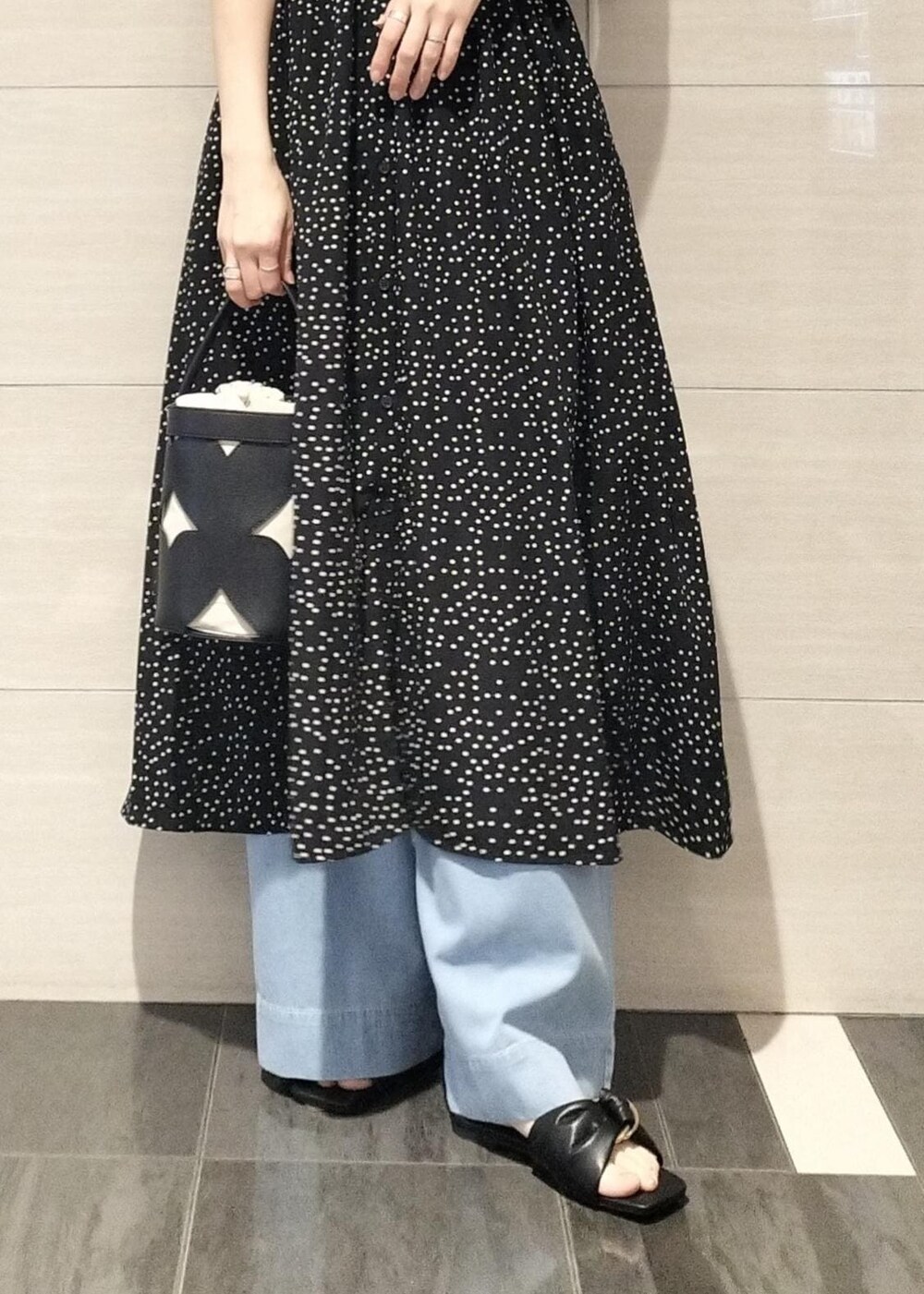 ブラック系のキャミソール、ブルー系のデニムパンツ、ブラック系のサンダルを着用したレディースの夏コーディネートの4枚目の写真