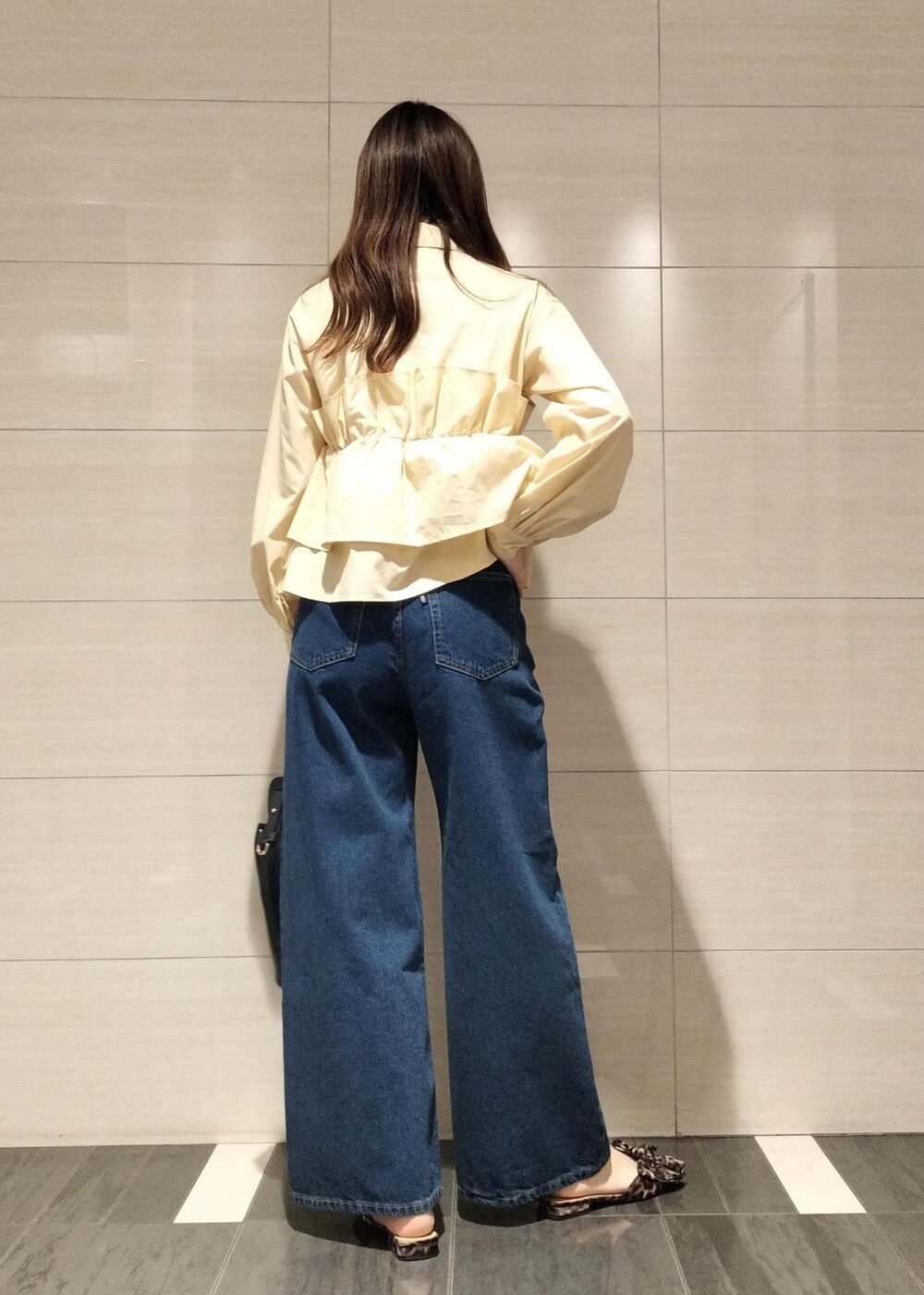 その他のサンダル、ブラック系のショルダーバッグ、ブルー系のデニムパンツを着用したレディースの秋コーディネートの7枚目の写真