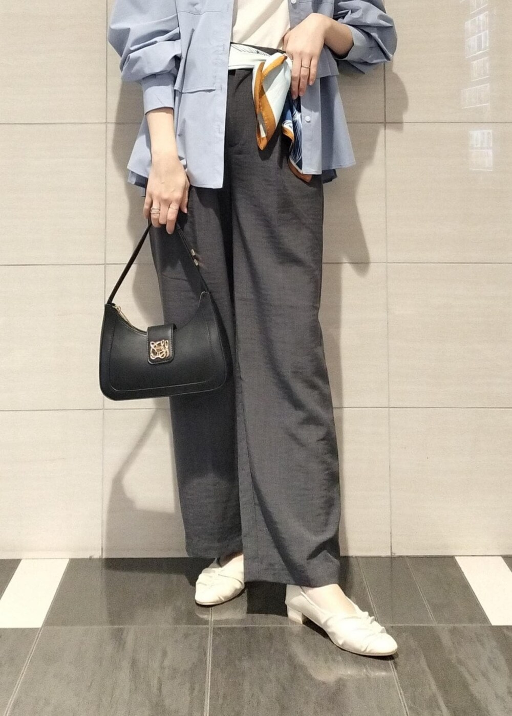 ブラック系のハンドバッグ、ホワイト系のキャミソール、グレー系のスラックスを着用したレディースの秋コーディネートの8枚目の写真