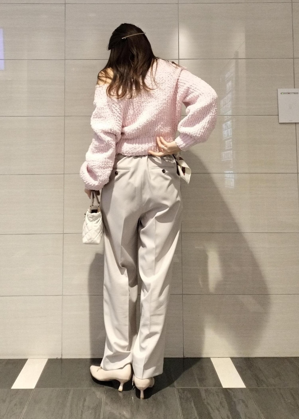 ピンク系のパンプス、ピンク系のニット/セーター、ベージュ系のスラックスを着用したレディースの冬コーディネートの4枚目の写真