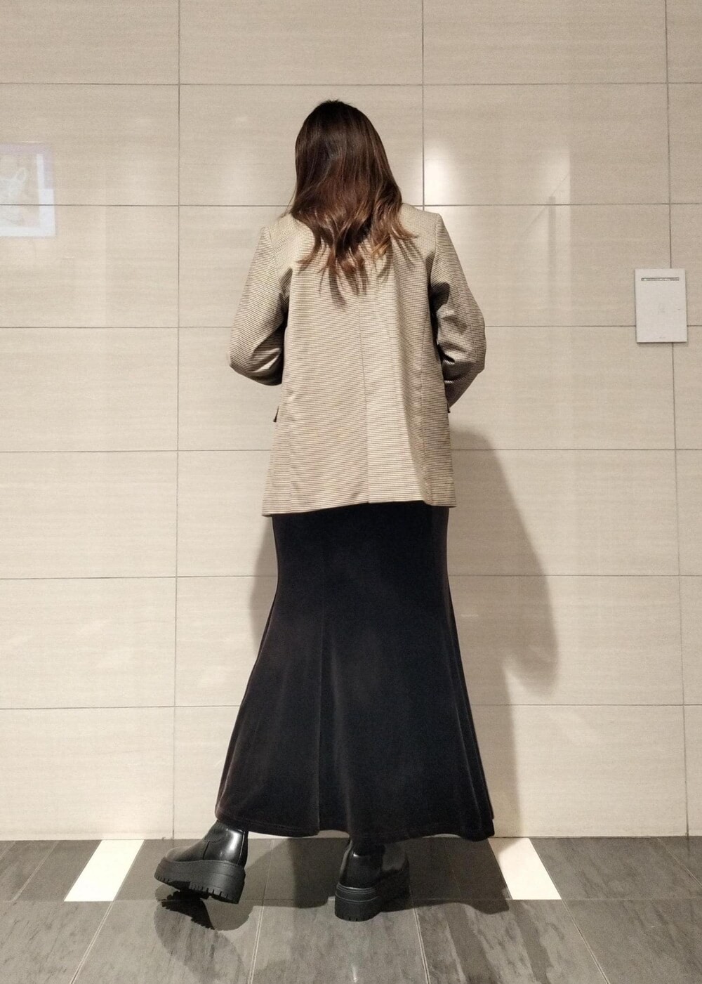 グレー系のショルダーバッグ、ベージュ系のテーラードジャケット、ブラック系のブーツを着用したレディースの秋コーディネートの5枚目の写真