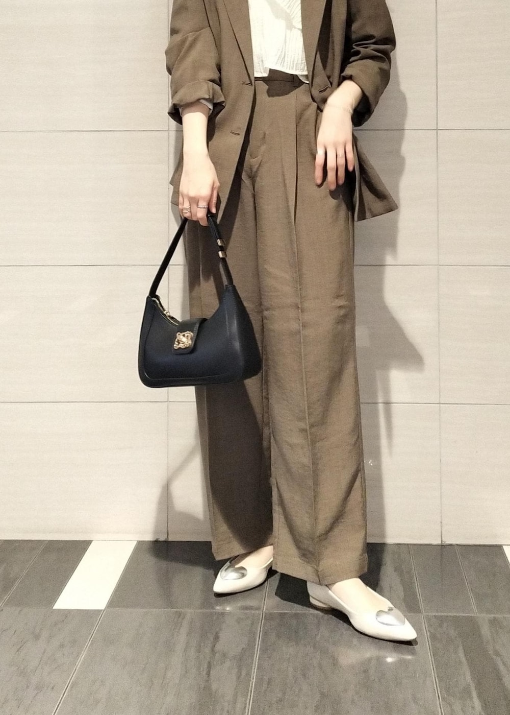 ブラック系のハンドバッグ、ホワイト系のシャツ/ブラウス、ホワイト系のバレエシューズを着用したレディースの春コーディネートの5枚目の写真