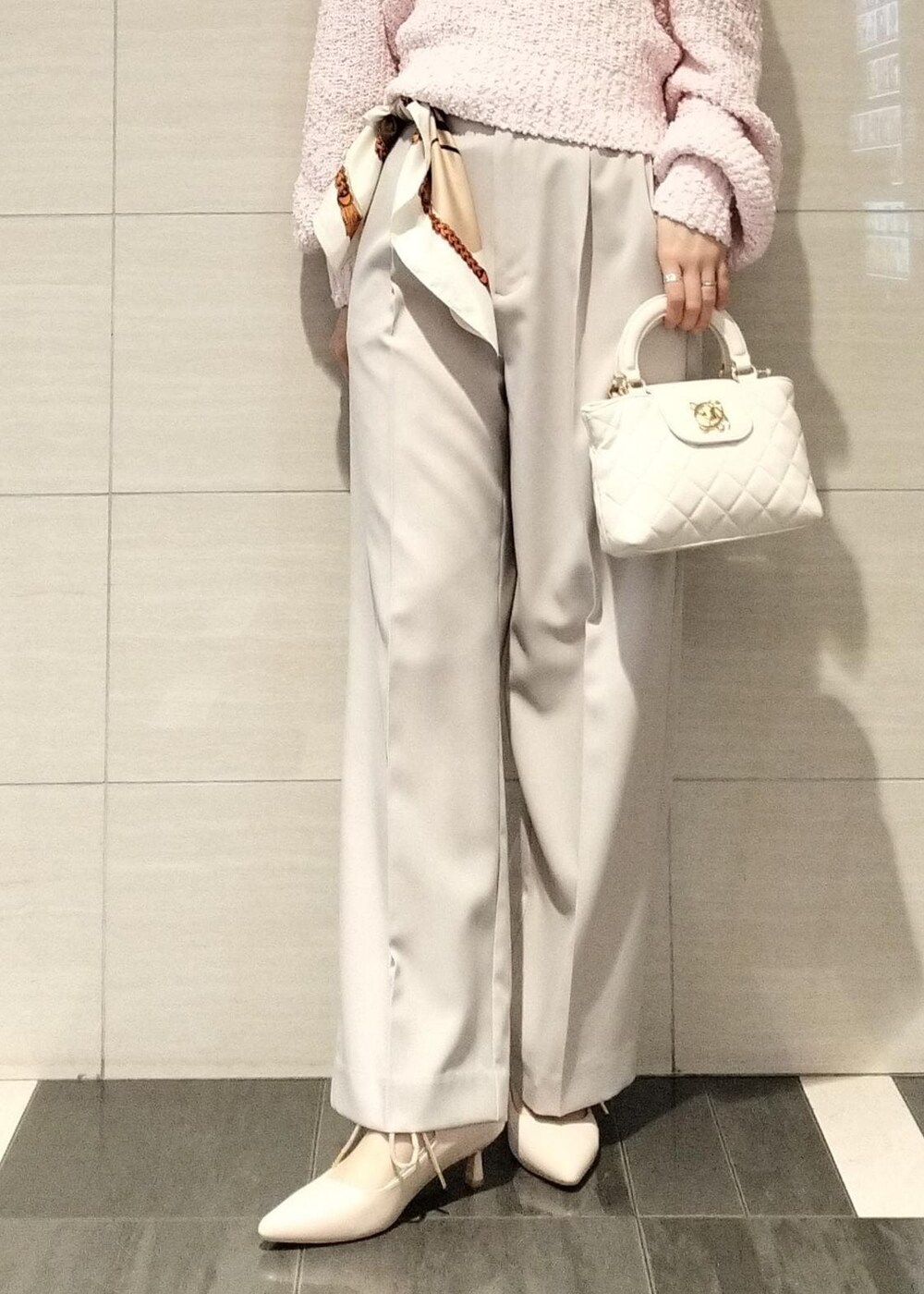 ピンク系のパンプス、ピンク系のニット/セーター、ベージュ系のスラックスを着用したレディースの冬コーディネートの3枚目の写真