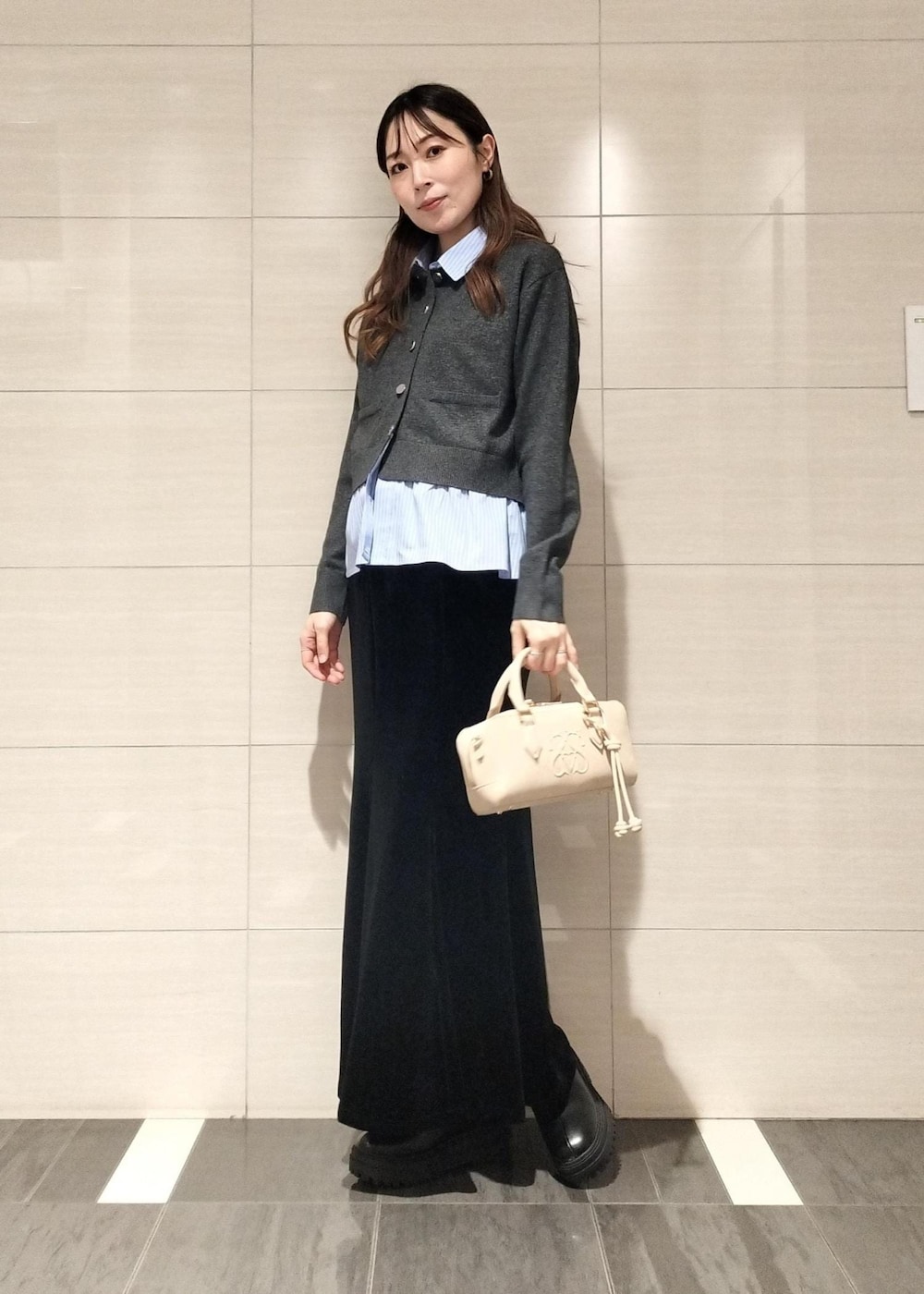 ベージュ系のボストンバッグ、ブラック系のブーツ、ブラウン系のキャミソールを着用したレディースの秋コーディネートの6枚目の写真