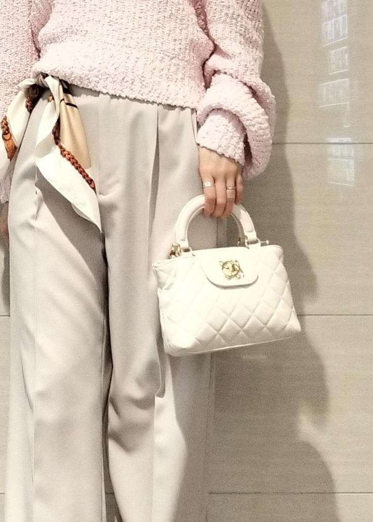 ピンク系のパンプス、ピンク系のニット/セーター、ベージュ系のスラックスを着用したレディースの冬コーディネートの5枚目の写真