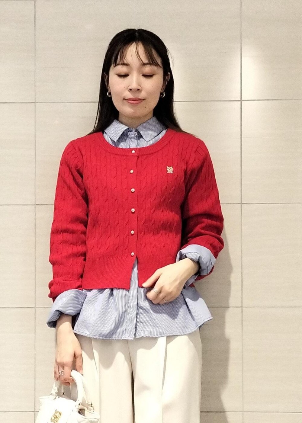 ブラック系のパンプス、ブルー系のシャツ/ブラウス、レッド系のカーディガン/ボレロを着用したレディースの冬コーディネートの7枚目の写真