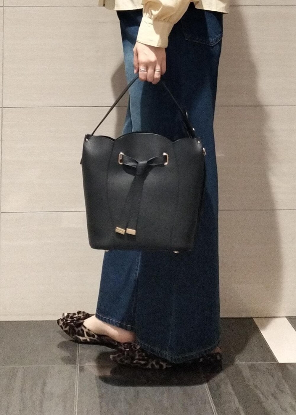 その他のサンダル、ブラック系のショルダーバッグ、ブルー系のデニムパンツを着用したレディースの秋コーディネートの6枚目の写真
