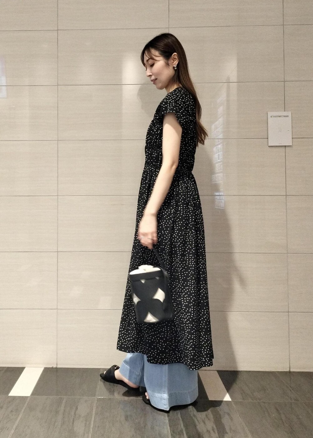 ブラック系のキャミソール、ブルー系のデニムパンツ、ブラック系のサンダルを着用したレディースの夏コーディネートの5枚目の写真