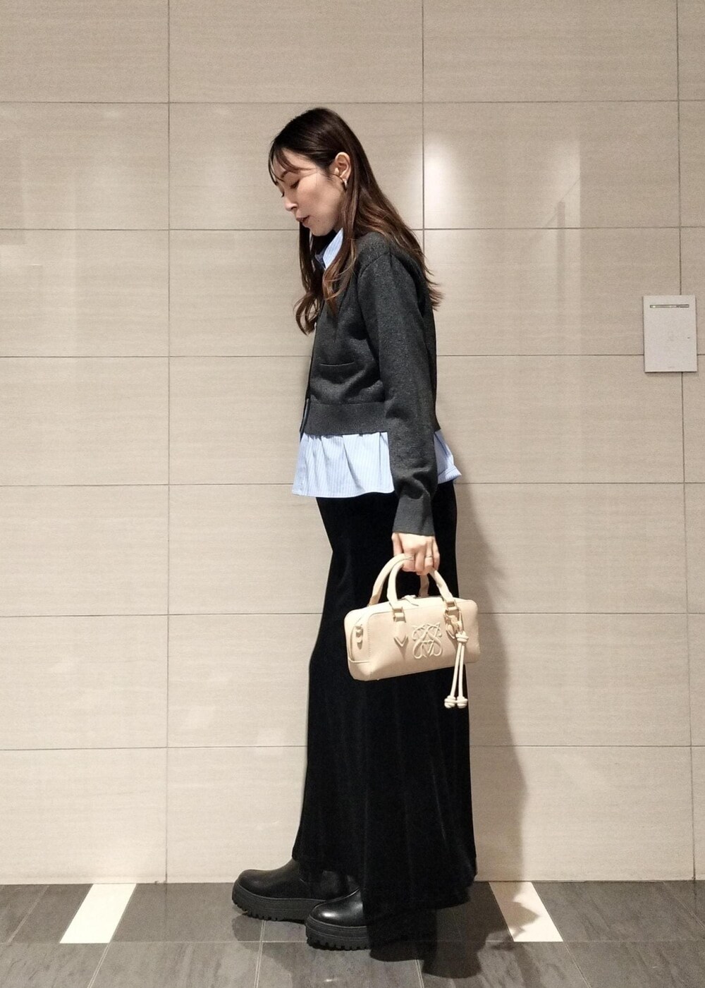 ベージュ系のボストンバッグ、ブラック系のブーツ、ブラウン系のキャミソールを着用したレディースの秋コーディネートの3枚目の写真