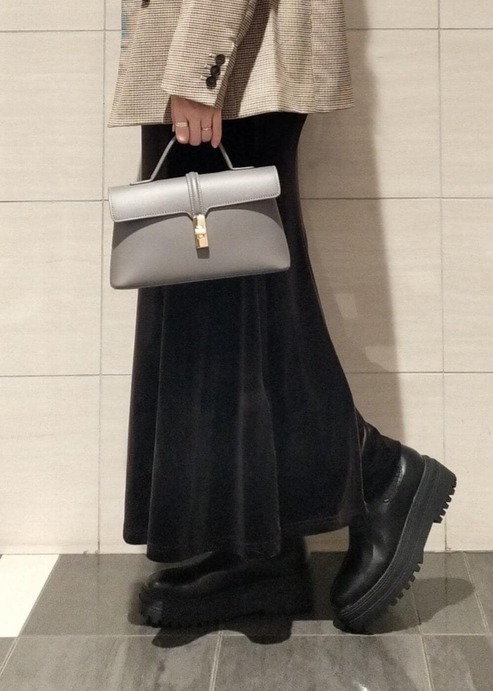 グレー系のショルダーバッグ、ベージュ系のテーラードジャケット、ブラック系のブーツを着用したレディースの秋コーディネートの3枚目の写真