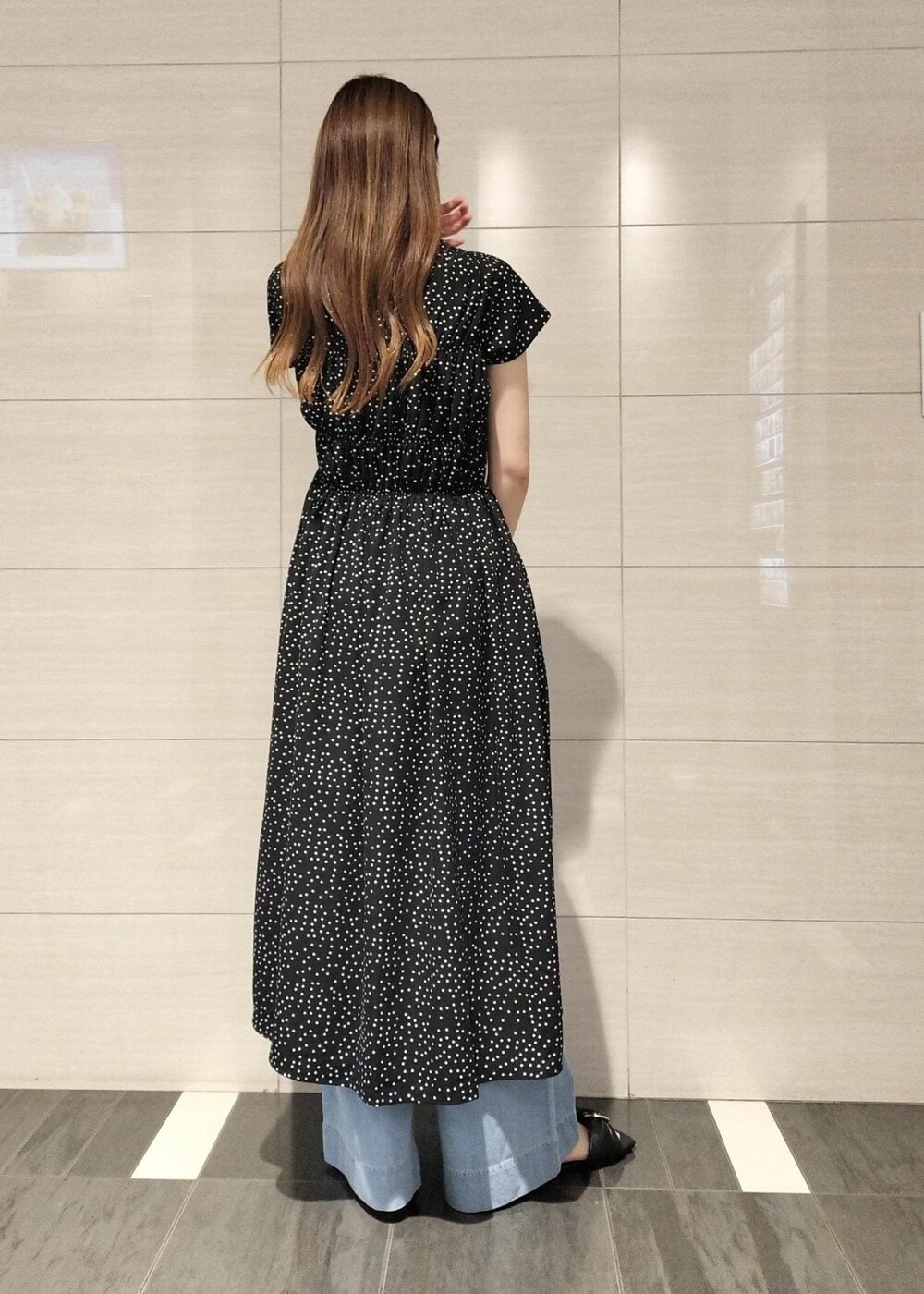 ブラック系のキャミソール、ブルー系のデニムパンツ、ブラック系のサンダルを着用したレディースの夏コーディネートの6枚目の写真