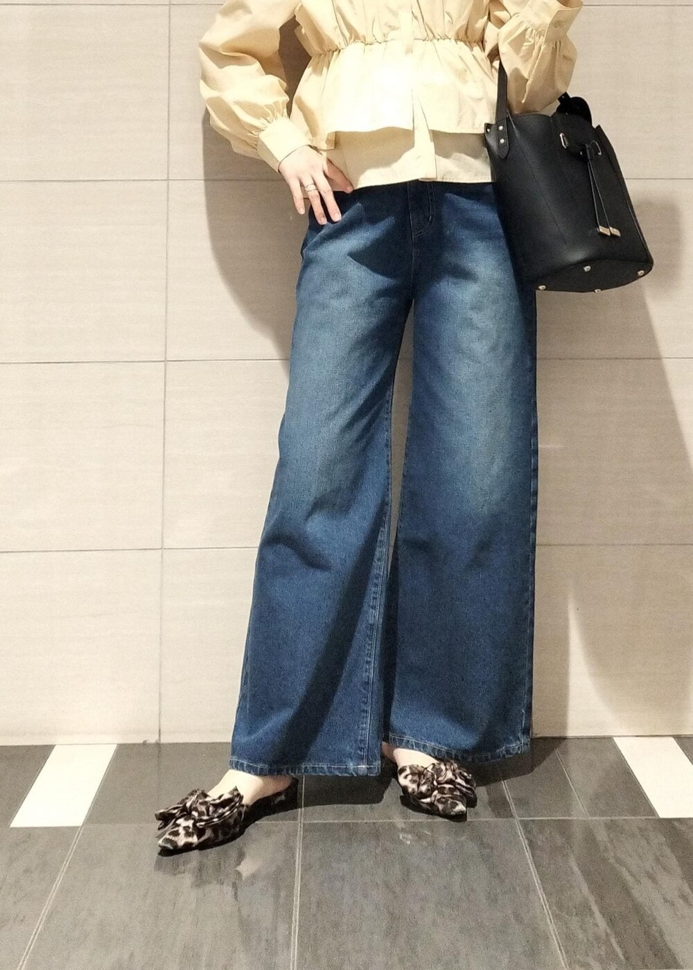 その他のサンダル、ブラック系のショルダーバッグ、ブルー系のデニムパンツを着用したレディースの秋コーディネートの4枚目の写真