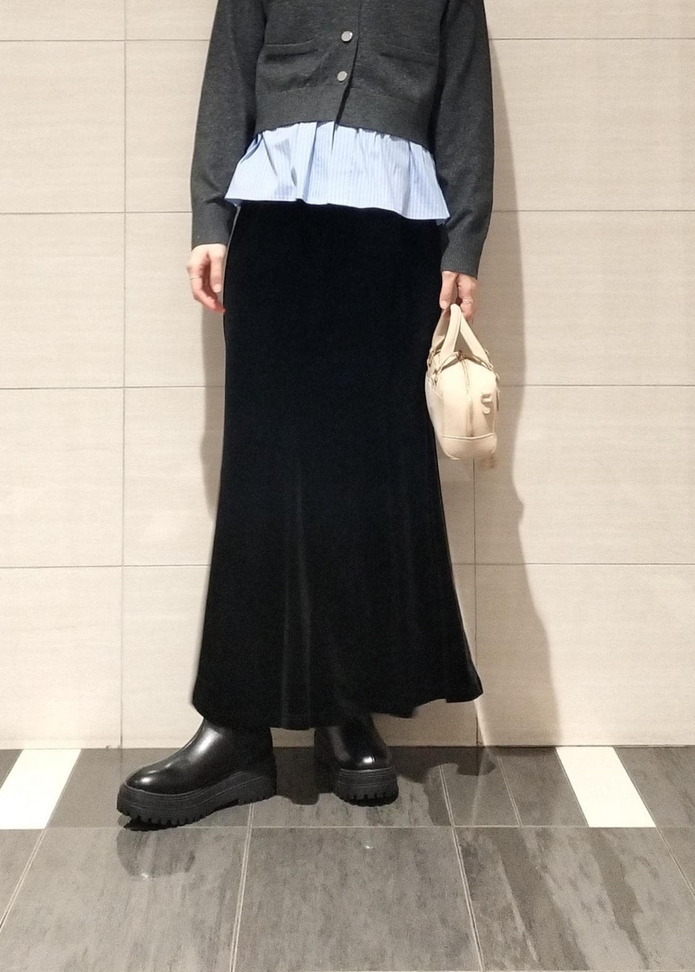 ベージュ系のボストンバッグ、ブラック系のブーツ、ブラウン系のキャミソールを着用したレディースの秋コーディネートの5枚目の写真