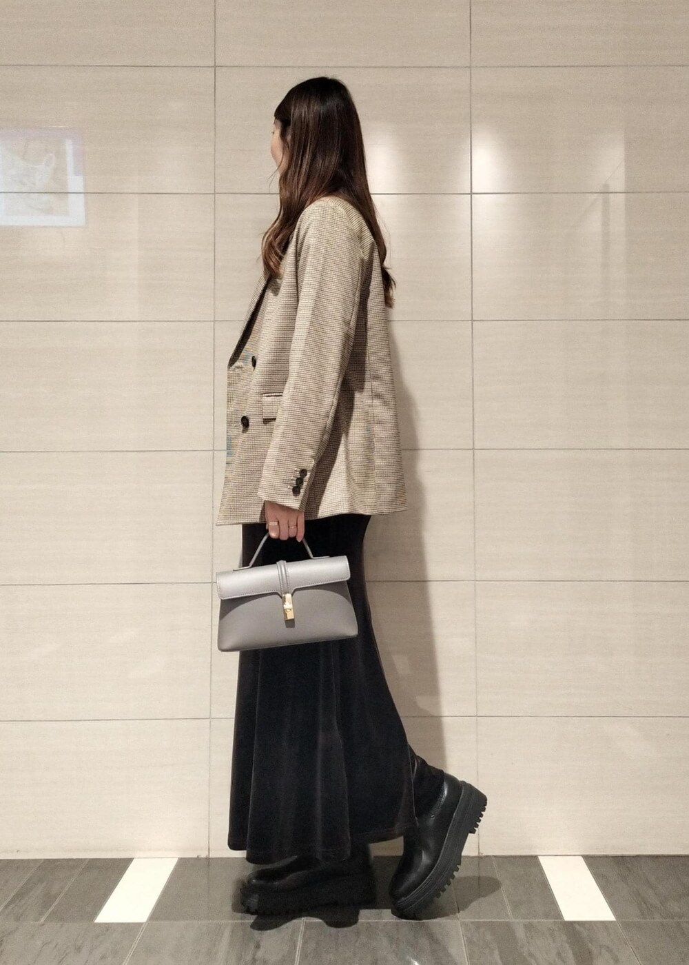 グレー系のショルダーバッグ、ベージュ系のテーラードジャケット、ブラック系のブーツを着用したレディースの秋コーディネートの4枚目の写真