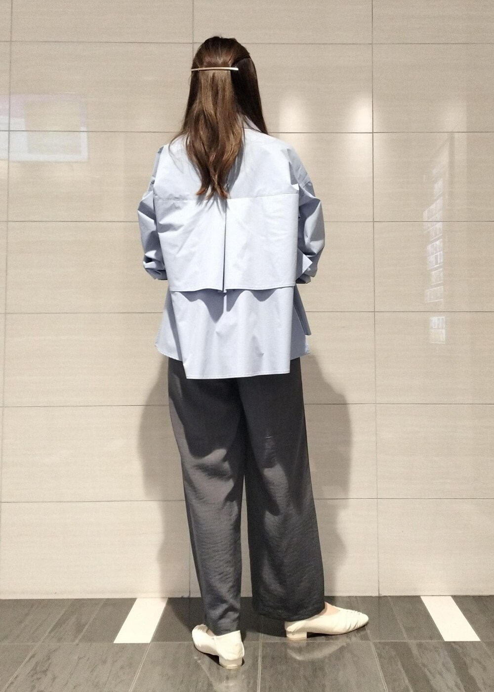 ブラック系のハンドバッグ、ホワイト系のキャミソール、グレー系のスラックスを着用したレディースの秋コーディネートの4枚目の写真