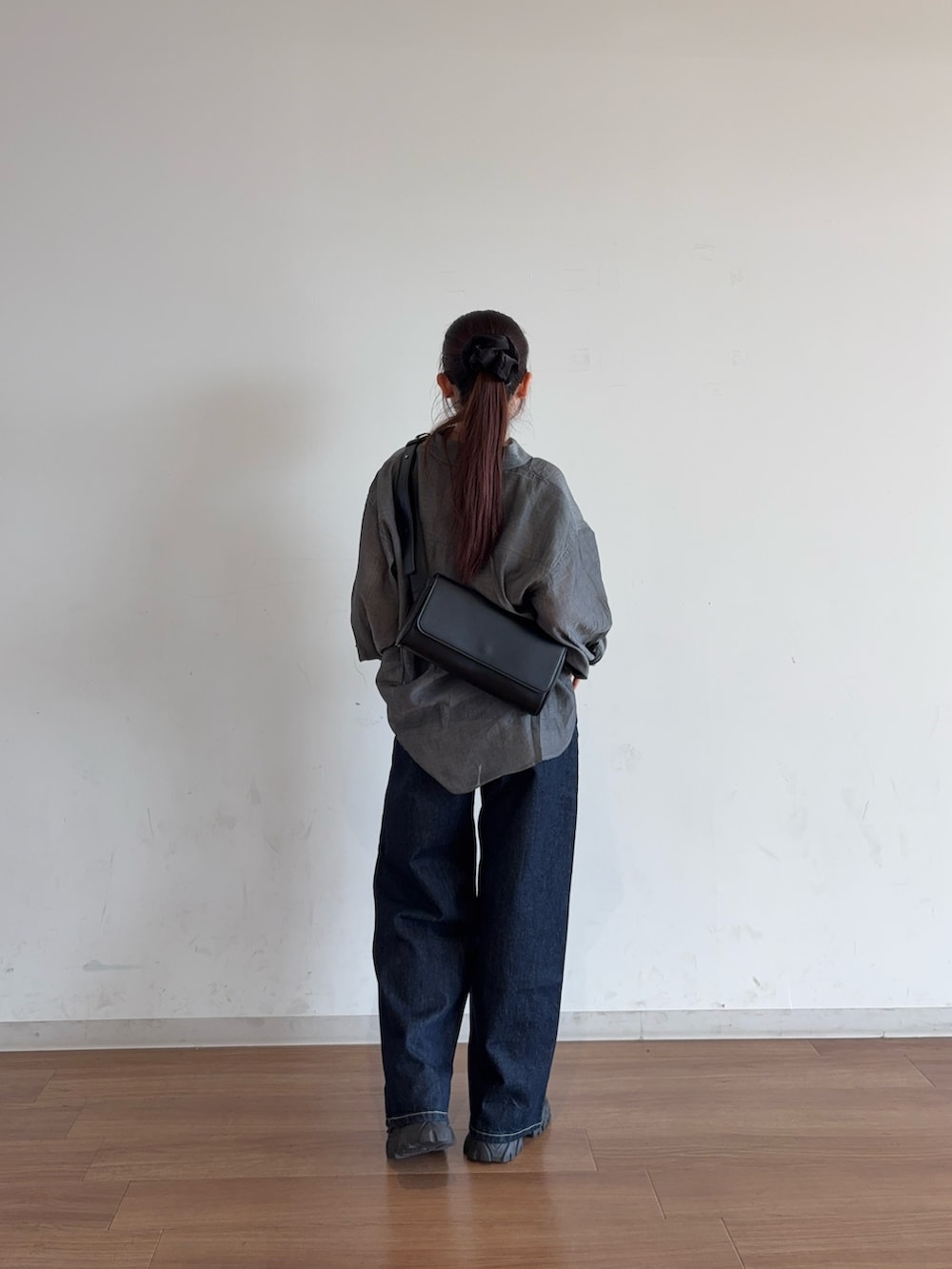 ブルー系のデニムパンツ、ブラック系のボディバッグ/ウエストポーチ、ブラック系のシャツ/ブラウスを着用したレディースの夏コーディネートの3枚目の写真