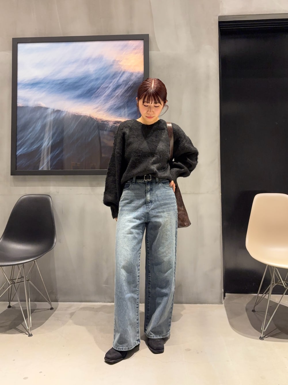 ブルー系のデニムパンツ、ブラック系のブーツ、ブラック系のニット/セーターを着用したレディースの冬コーディネートの4枚目の写真