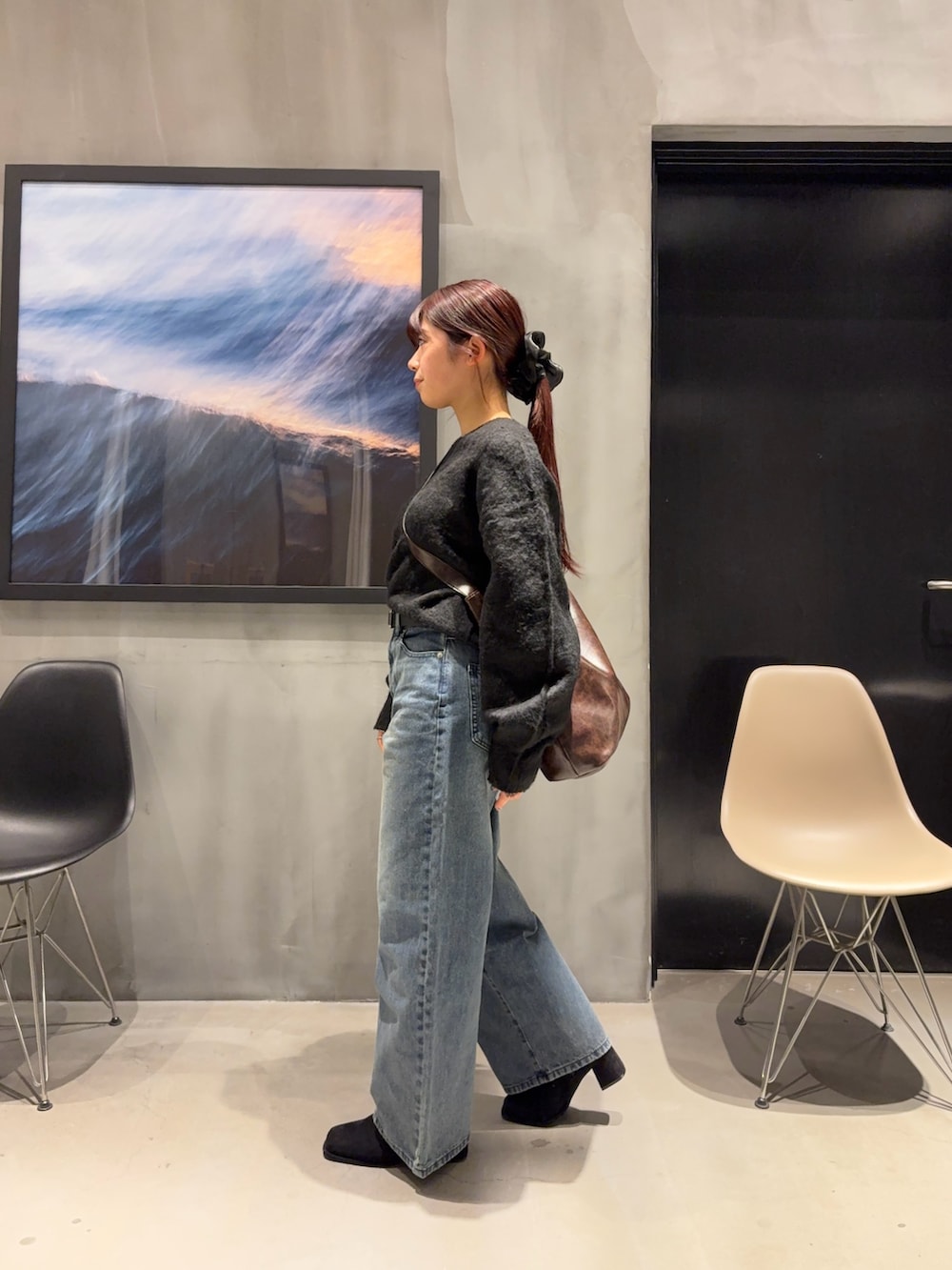 ブルー系のデニムパンツ、ブラック系のブーツ、ブラック系のニット/セーターを着用したレディースの冬コーディネートの2枚目の写真