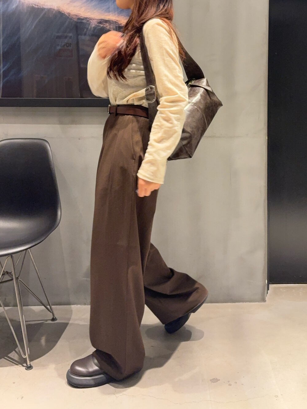 ブラウン系のスラックス、ホワイト系のTシャツ/カットソー、ブラウン系のショルダーバッグを着用したレディースの秋コーディネートの2枚目の写真